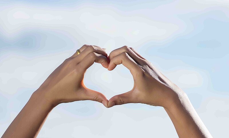 Zwei Hände formen ein Herz als Symbol für Engagement und Unterstützung
