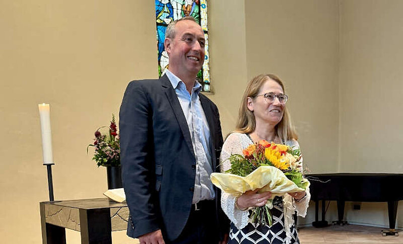 Der Geschäftsführer der Regionalen Diakonie in Hessen-Nassau, Volker Knöll und Ulrike Gürlet stehen nebeneinander.