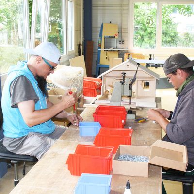 Zwei Männer basteln an einem Holzhaus in der Werkstatt Wetterau