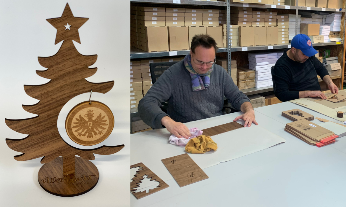 In der Reha-Werkstatt Wetterau arbeiten zwei Beschäftigte an der Produktion des Eintracht-Frankfurt Weihnachtsbaums
