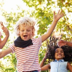 Kinder springen lachend in die Luft, Motiv der Herbstsammlung 2023 der Regionalen Diakonie Hessen-Nassau.